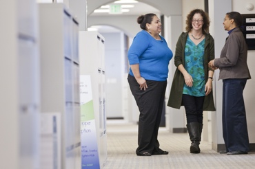 three women talking in a hallway